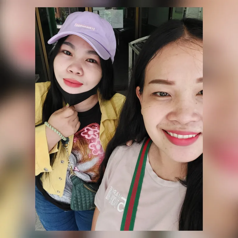 ภาพเซลฟีคนไข้หญิงสองคนยิ้มหน้าประตูทางเข้าคลินิกหลังเข้ารับบริการทำฟัน คลินิกทันตกรรม AuraWhite บางพลี